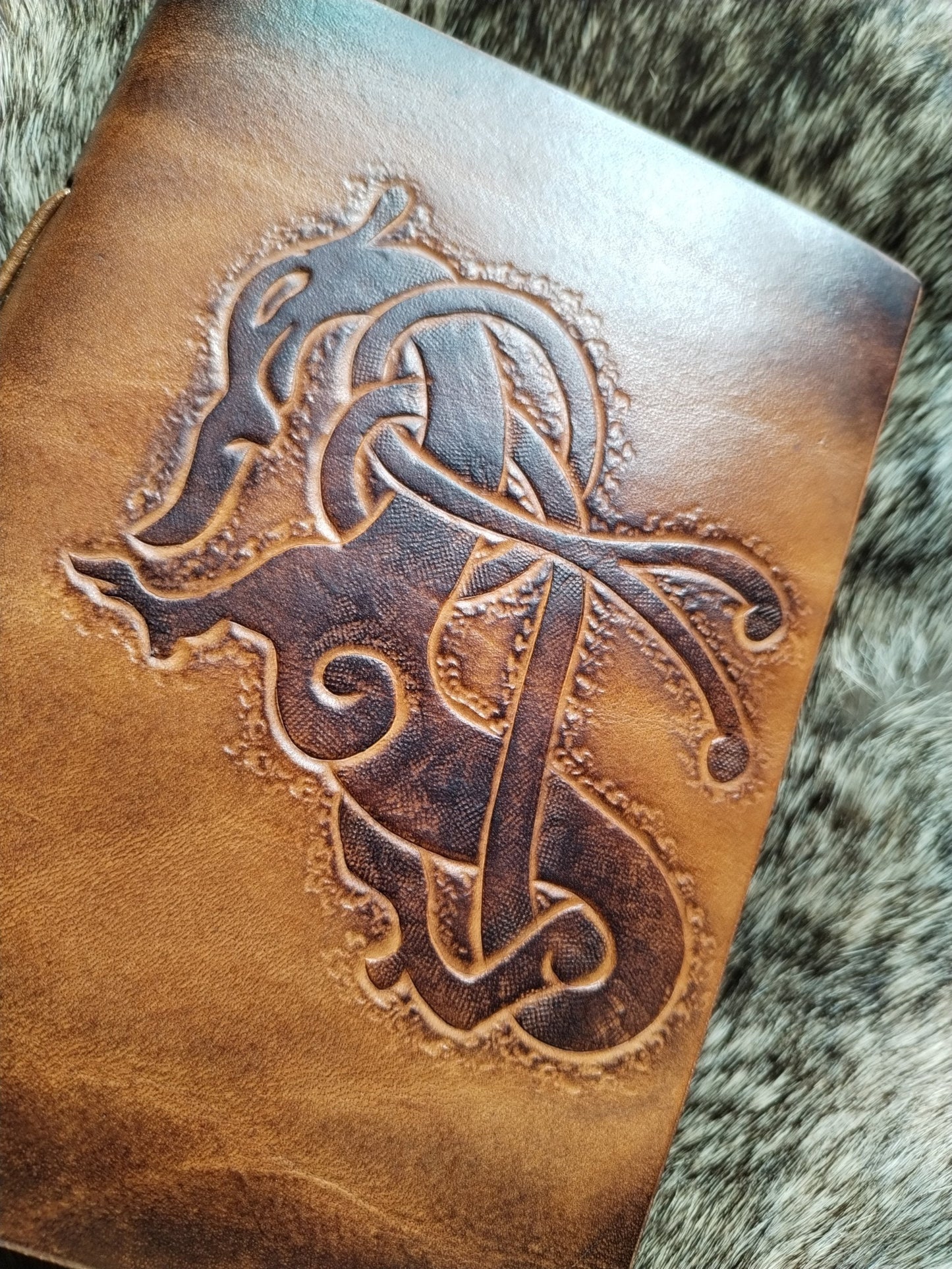 carnet en cuir avec dragon viking de face posé sur une fourrure Amrod & Gardarson