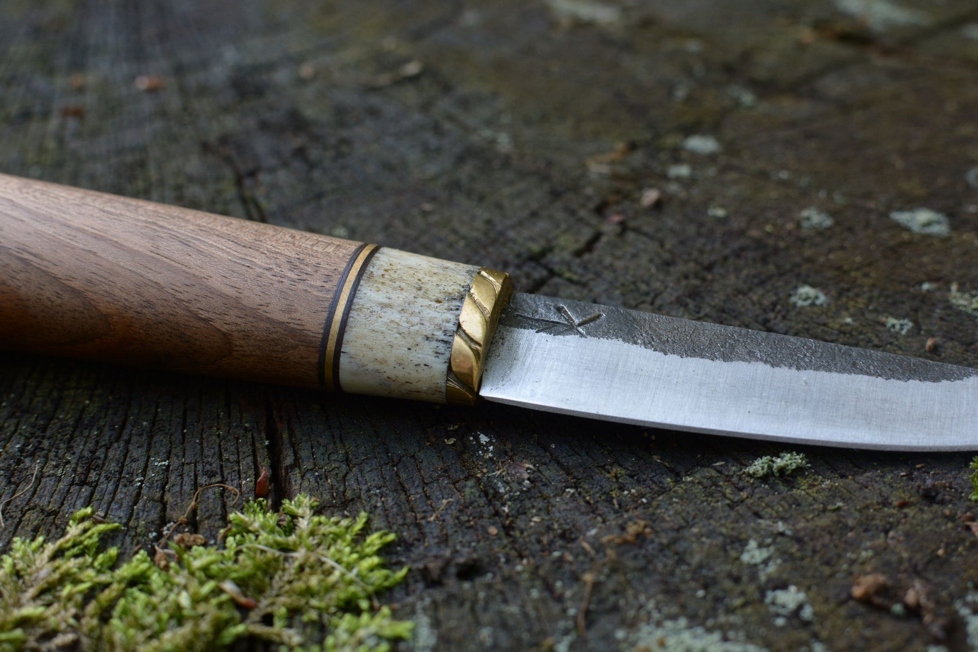 Couteau Yakut forgé main acier XC75 - détail lame asymétrique gorge martelée manche noyer bois de cerf guillochage mitre laiton