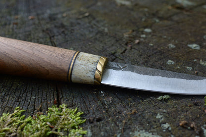 Couteau Yakut forgé main acier XC75 - détail lame asymétrique gorge martelée manche noyer bois de cerf guillochage mitre laiton