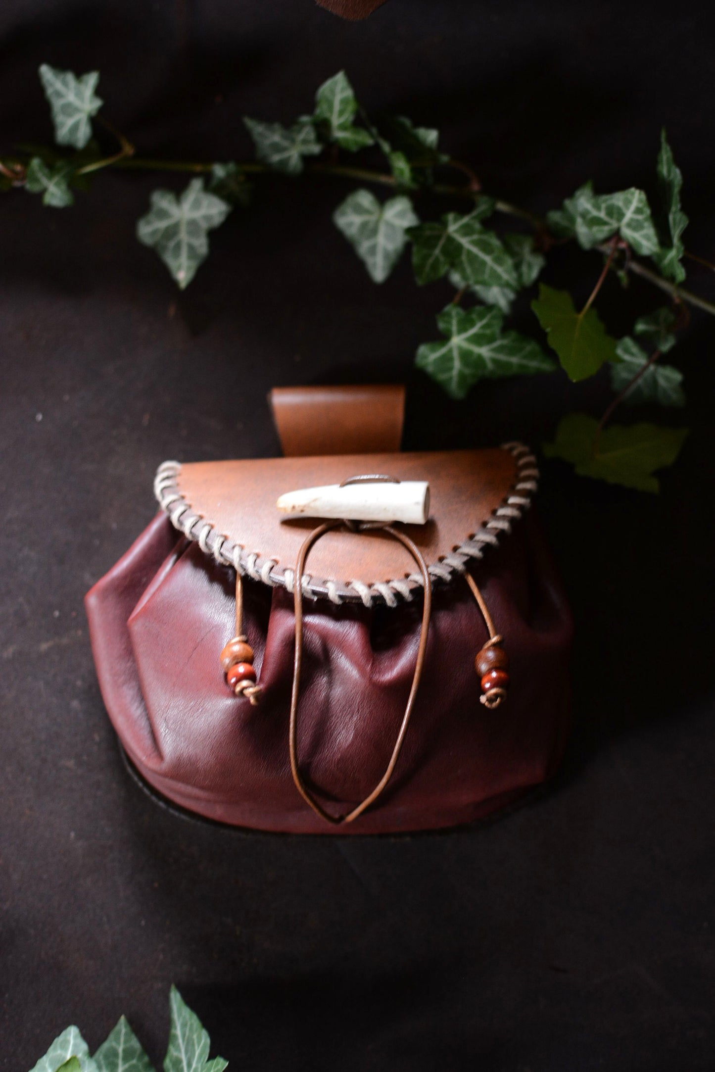 bourse en cuir et bois de cerf (de face) avec feuilles de lierre en fond