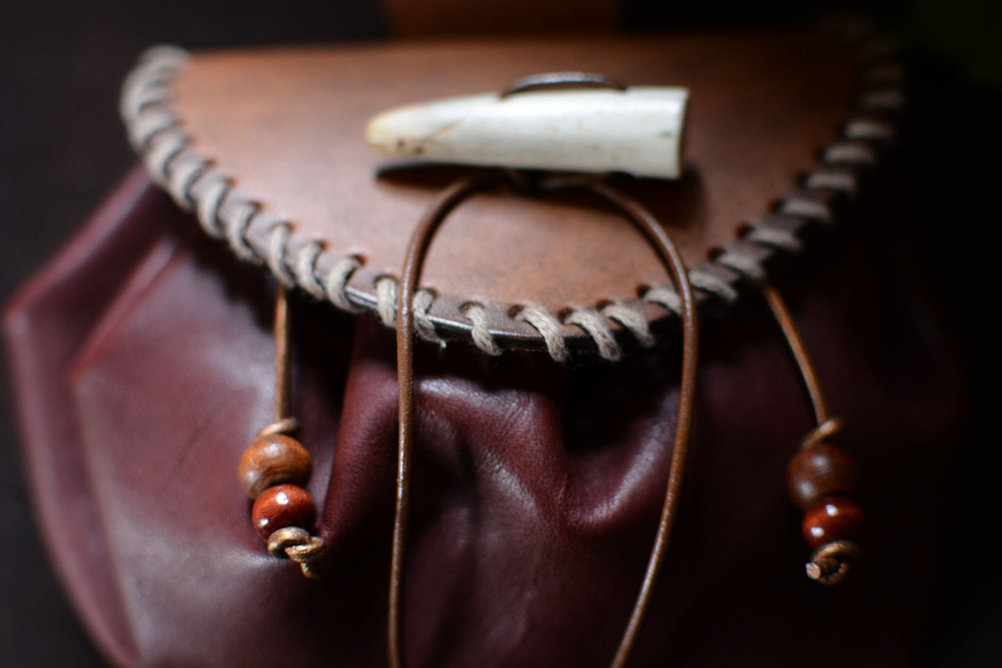 Détail de la bourse: laçage en fil de chanvre, perles en bois et bois de cerf
