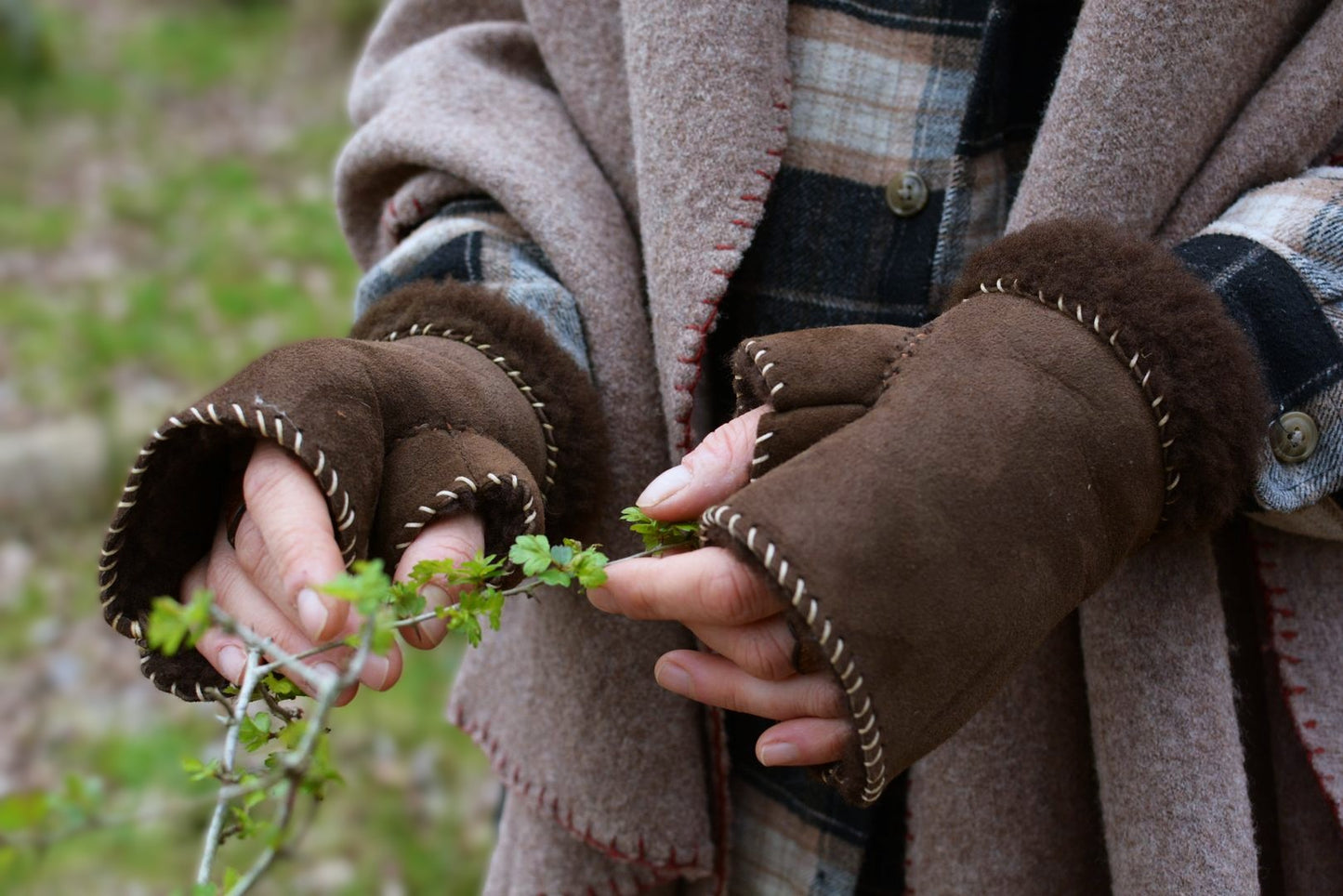 Mitaines en peau de mouton retournée (shearling) portées en extérieur, cadre naturel hivernal