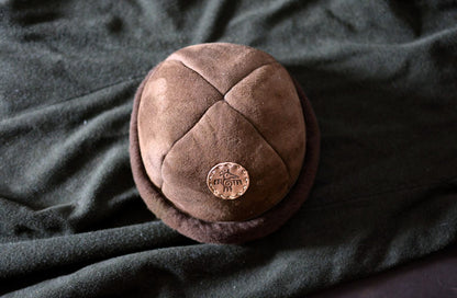 Vue de dessus du bonnet shearling mouton, détail des coutures artisanales et patch oiseau