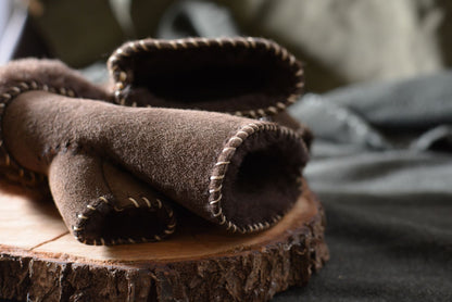 Détail cuir suède, fourrure de mouton et bordure à laçage décoratif des mitaines shearling