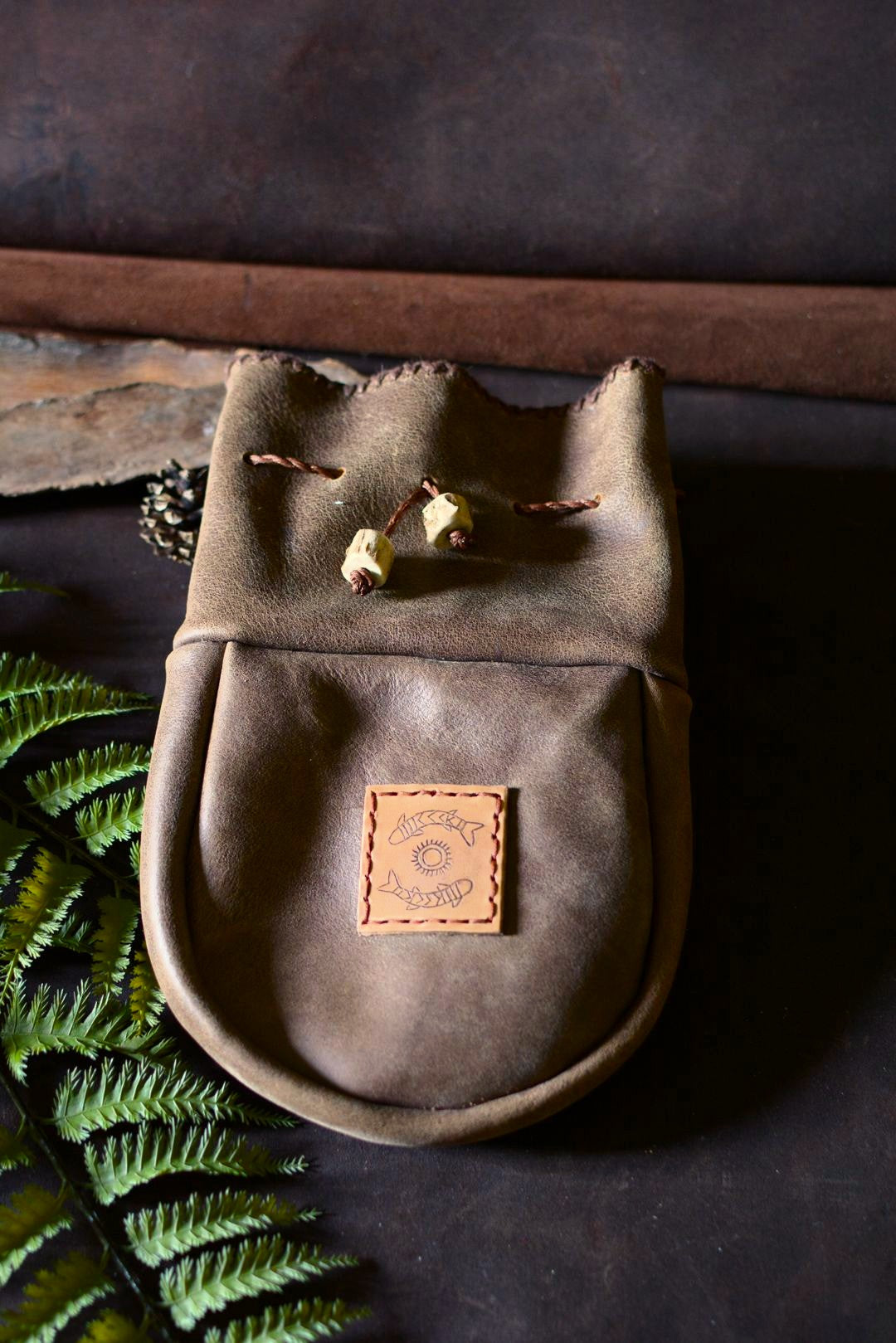 Grande bourse cuir artisanale Forge Gardarson, face, patch pétroglyphe et perles en bois de chevreuil