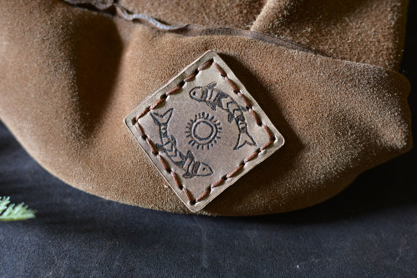 Détail du patch pétroglyphe cerf sur le petit sac cuir Forge Gardarson