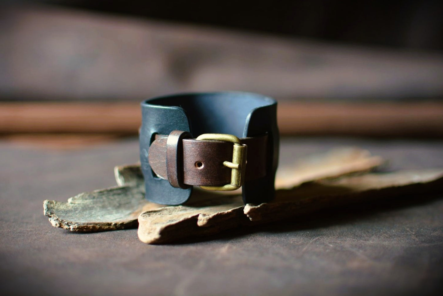 Détail boucle ardillon laiton massif sur bracelet de force cuir noir et marron — fabrication artisanale française