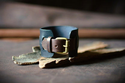 Détail boucle ardillon laiton massif sur bracelet de force cuir noir et marron — fabrication artisanale française