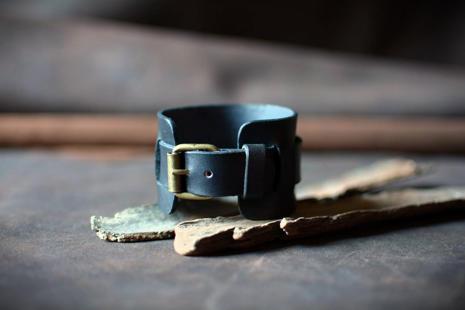 "Bracelet de force en cuir noir — vue boucle ardillon laiton apparente"