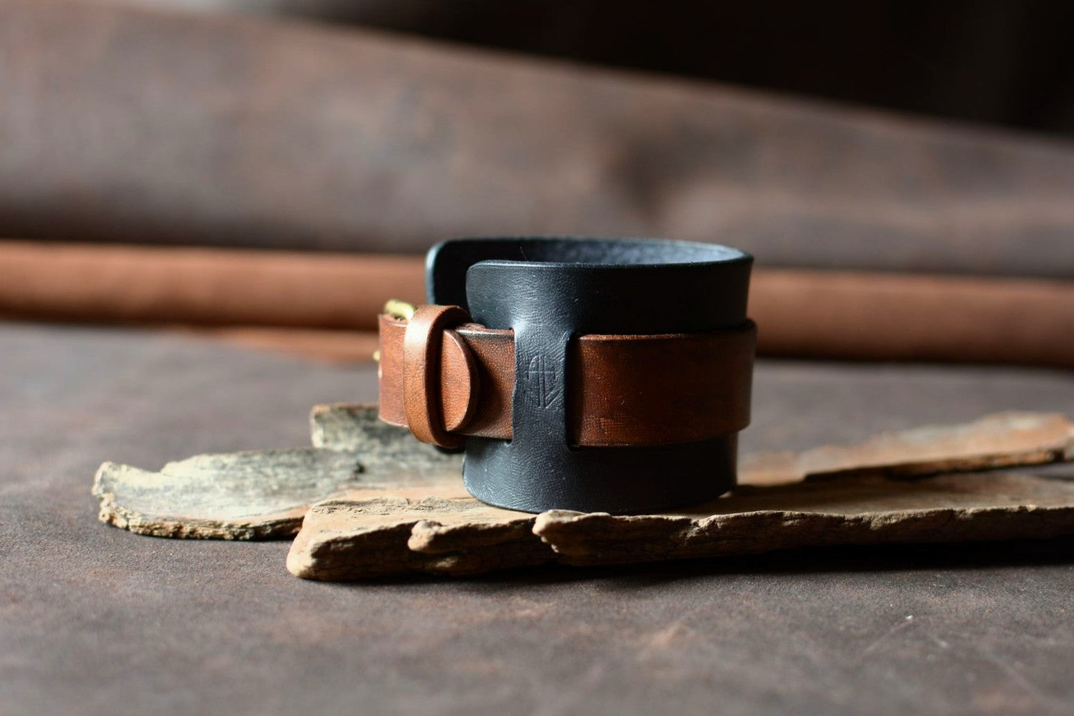 Détail bout de sangle cuir tannage végétal noir et havane — finition artisanale française