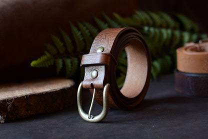 Ceinture batik havane en cuir tannage végétal roulée, décor studio fougère et rondin de bois – Amrod & Gardarson