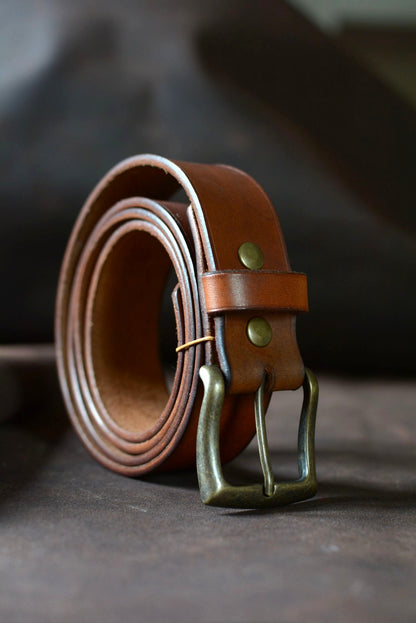 Ceinture cuir tannage végétal havane roulée de profil – boucle rectangle laiton – Amrod & Gardarson