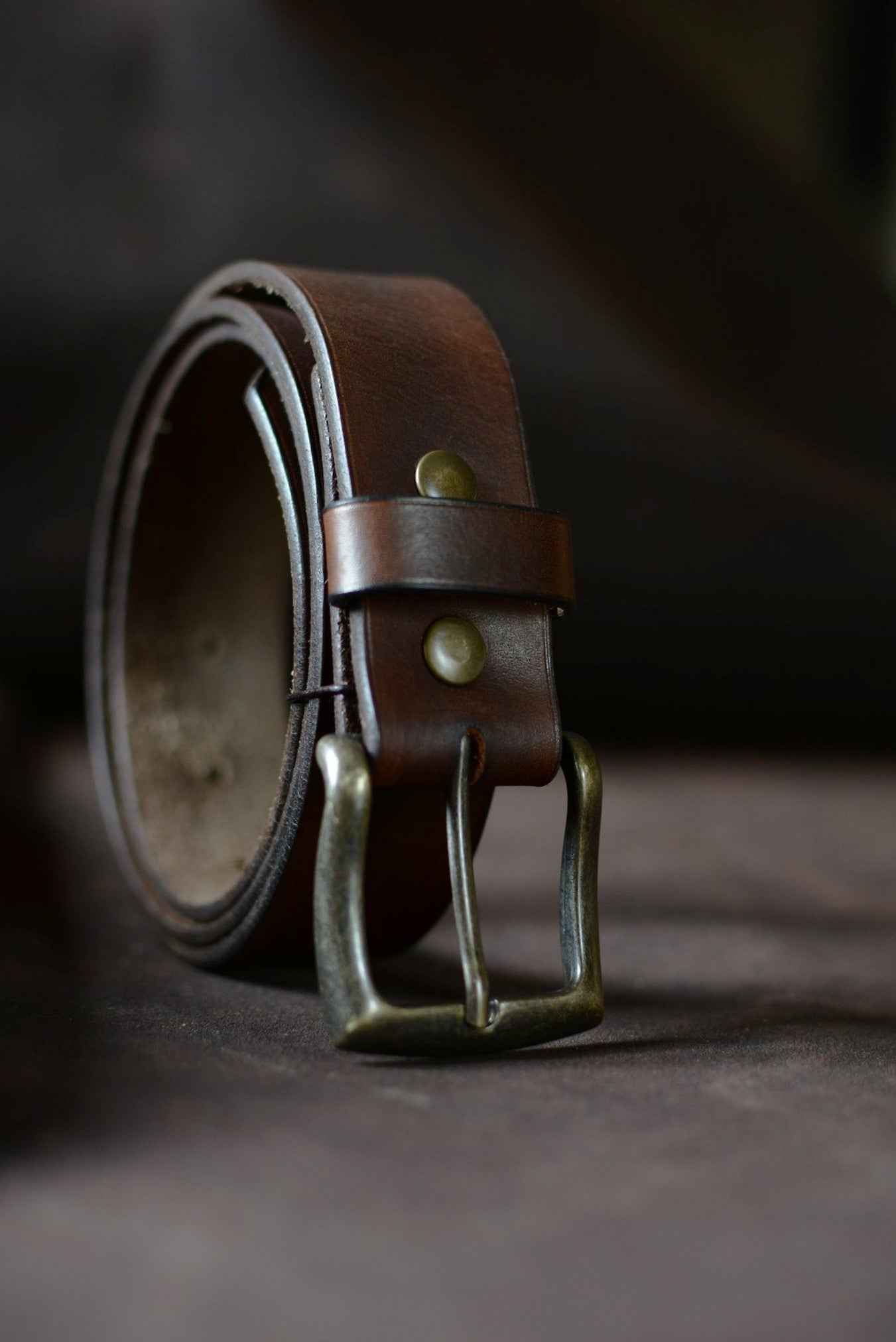 Ceinture cuir tannage végétal marron foncé roulée de profil – boucle rectangle laiton – Amrod & Gardarson