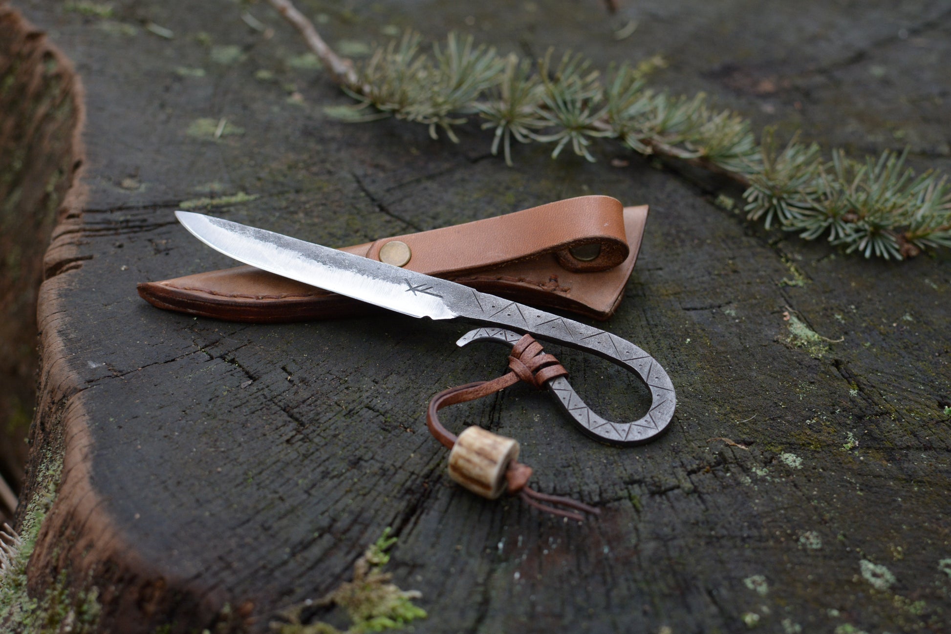 Petit couteau celte forgé main tout acier gravures primitives avec étui cuir - vue de face sur souche de bois - Forge Gardarson