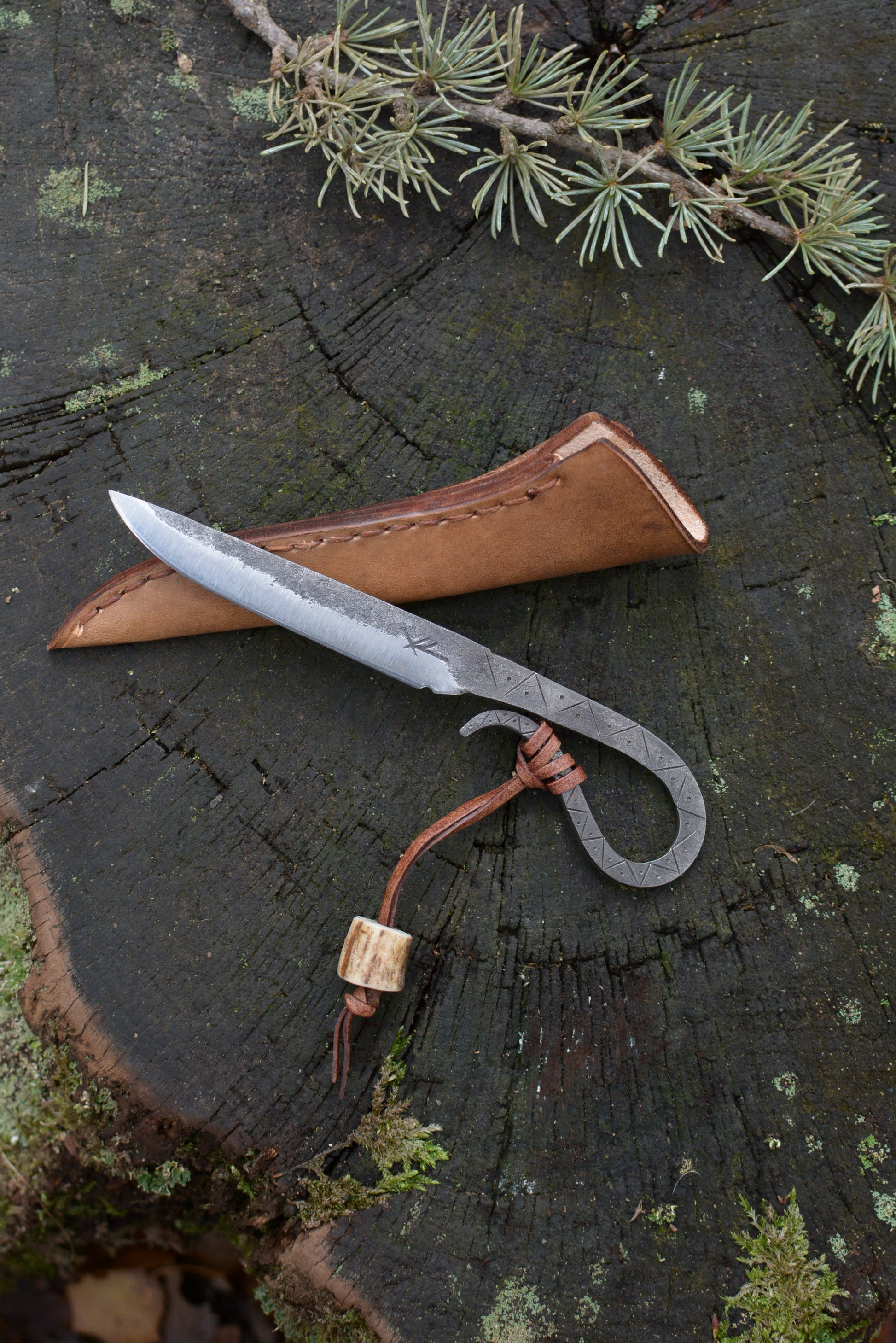Petit couteau celte forgé main tout acier gravures primitives avec étui cuir - vue de face sur souche de bois - Forge Gardarson