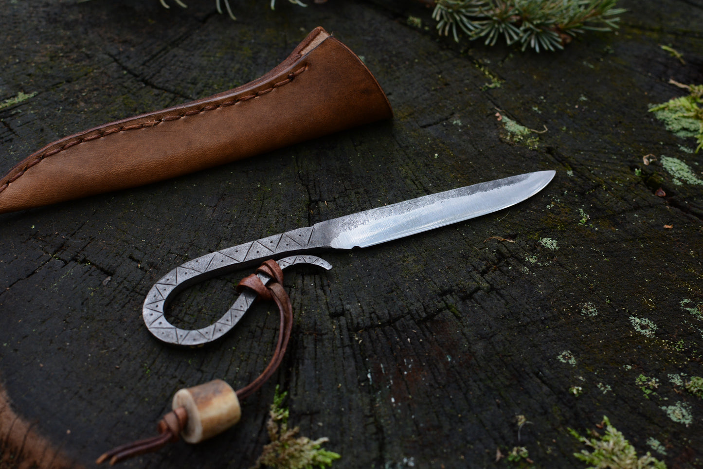 Petit couteau celte forgé main tout acier gravures primitives avec étui cuir - vue de face sur souche de bois - Forge Gardarson