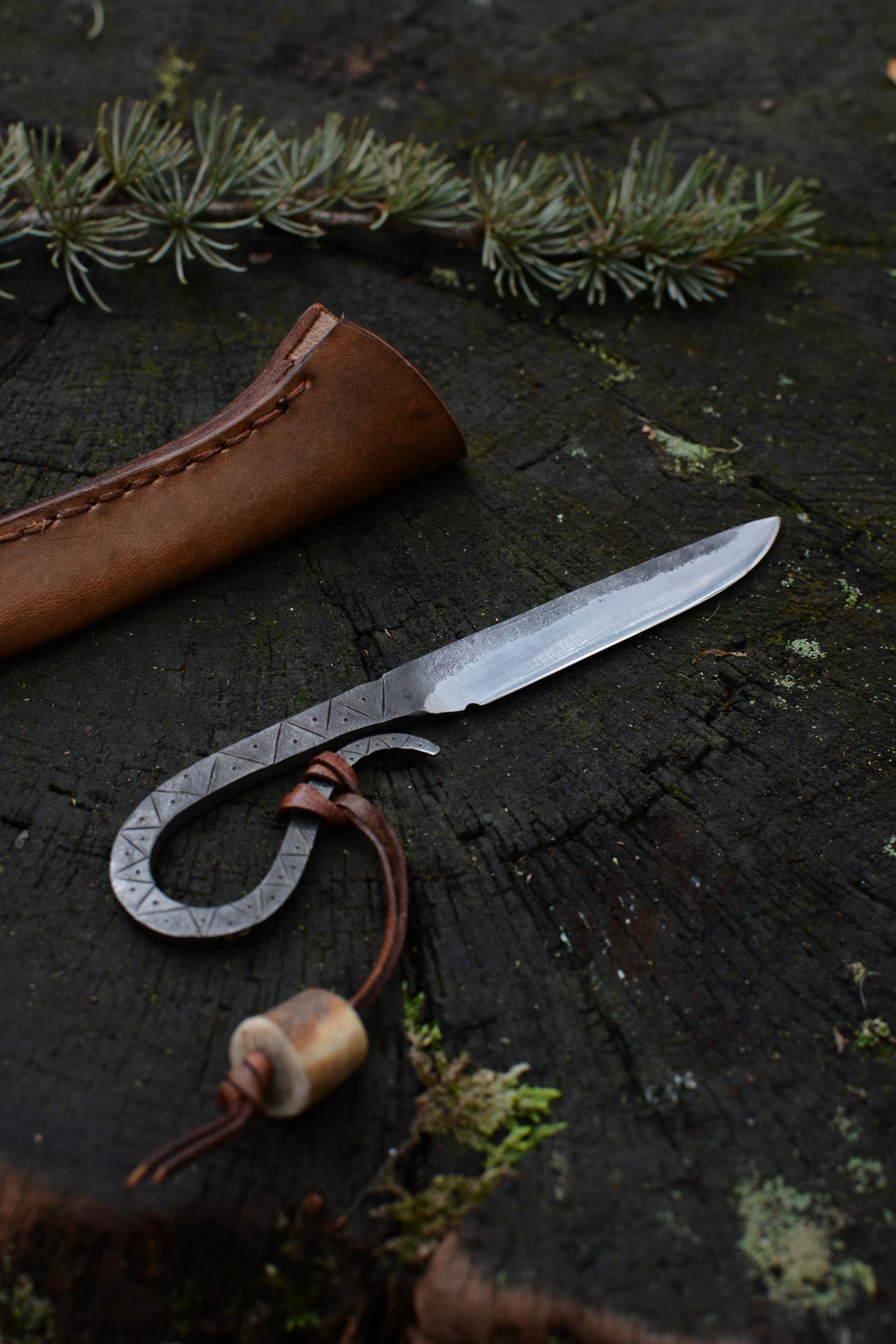 Petit couteau celte forgé main tout acier gravures primitives avec étui cuir - vue de face sur souche de bois - Forge Gardarson