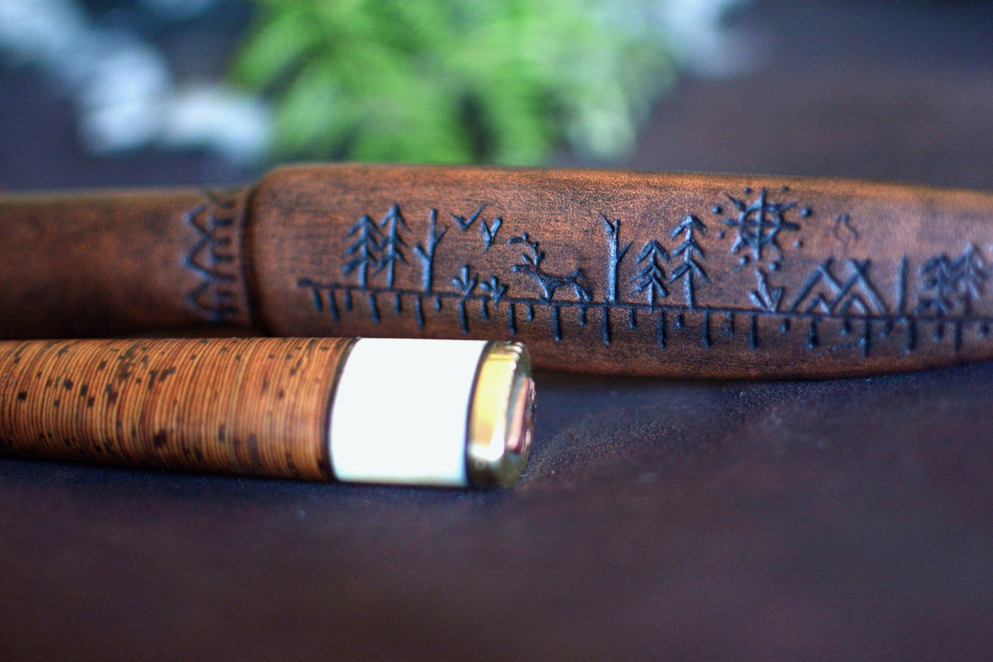 Détail motif pétroglyphe gravé sur gaine cuir moulé — étui sur-mesure Atelier d'Amrod — puukko artisanal