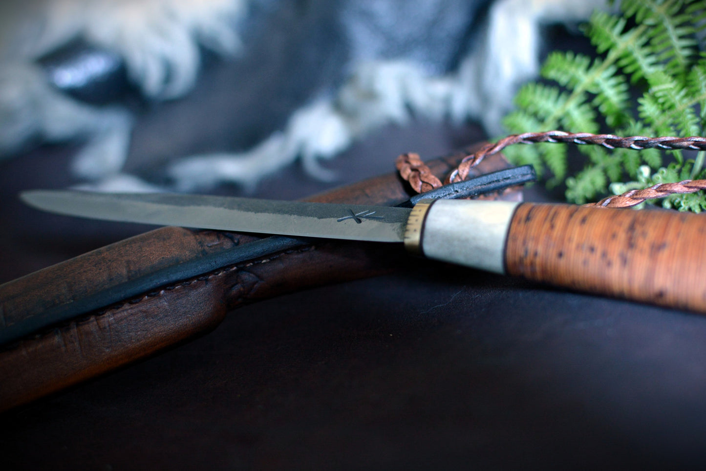 Détail tranchant lame puukko — acier carbone forgé au marteau — couteau bushcraft scandinave

