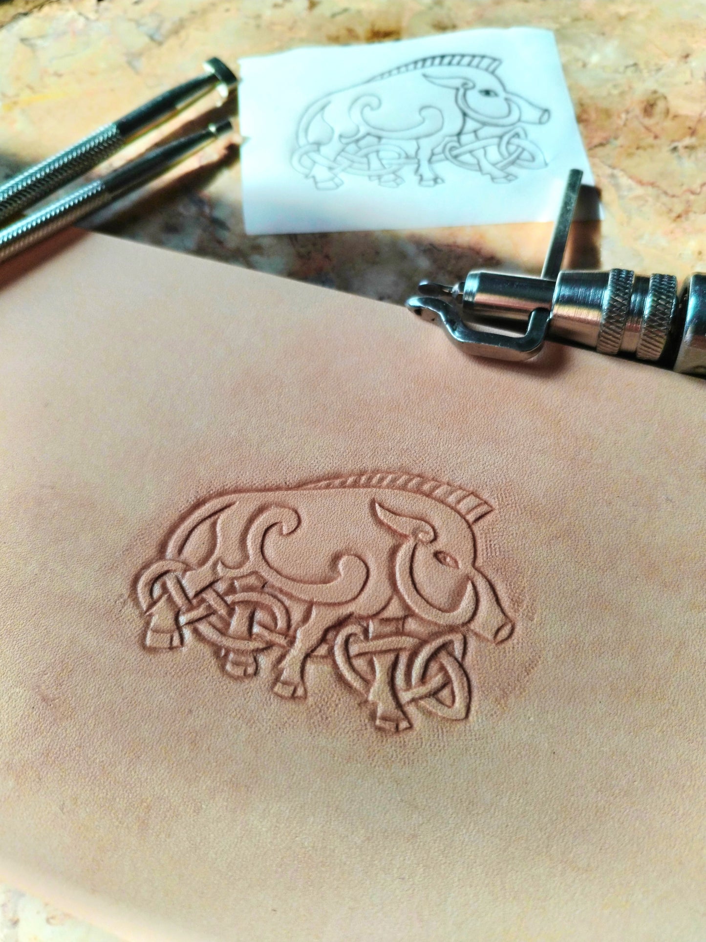Repoussage à la main du motif sanglier celtique sur cuir tannage végétal - savoir-faire artisanal Atelier d'Amrod
