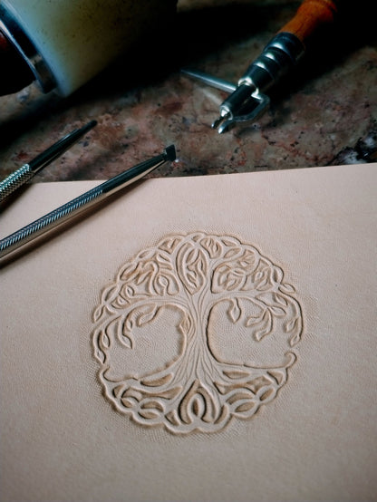 Repoussage à la main du motif arbre de vie sur cuir tannage végétal - savoir-faire artisanal Atelier d'Amrod
Flasque inox et cuir motif arbre de vie 