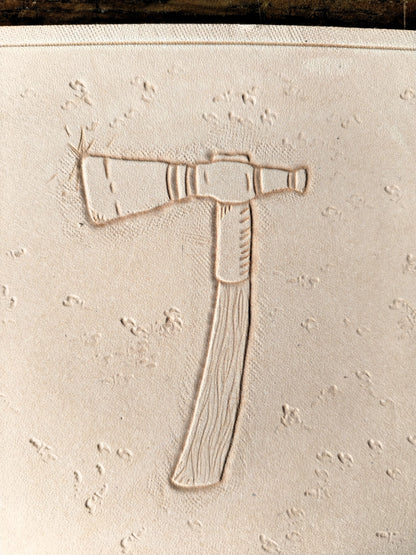 Repoussage à la main du motif tomahawk sur cuir tannage végétal - savoir-faire artisanal Atelier d'Amrod