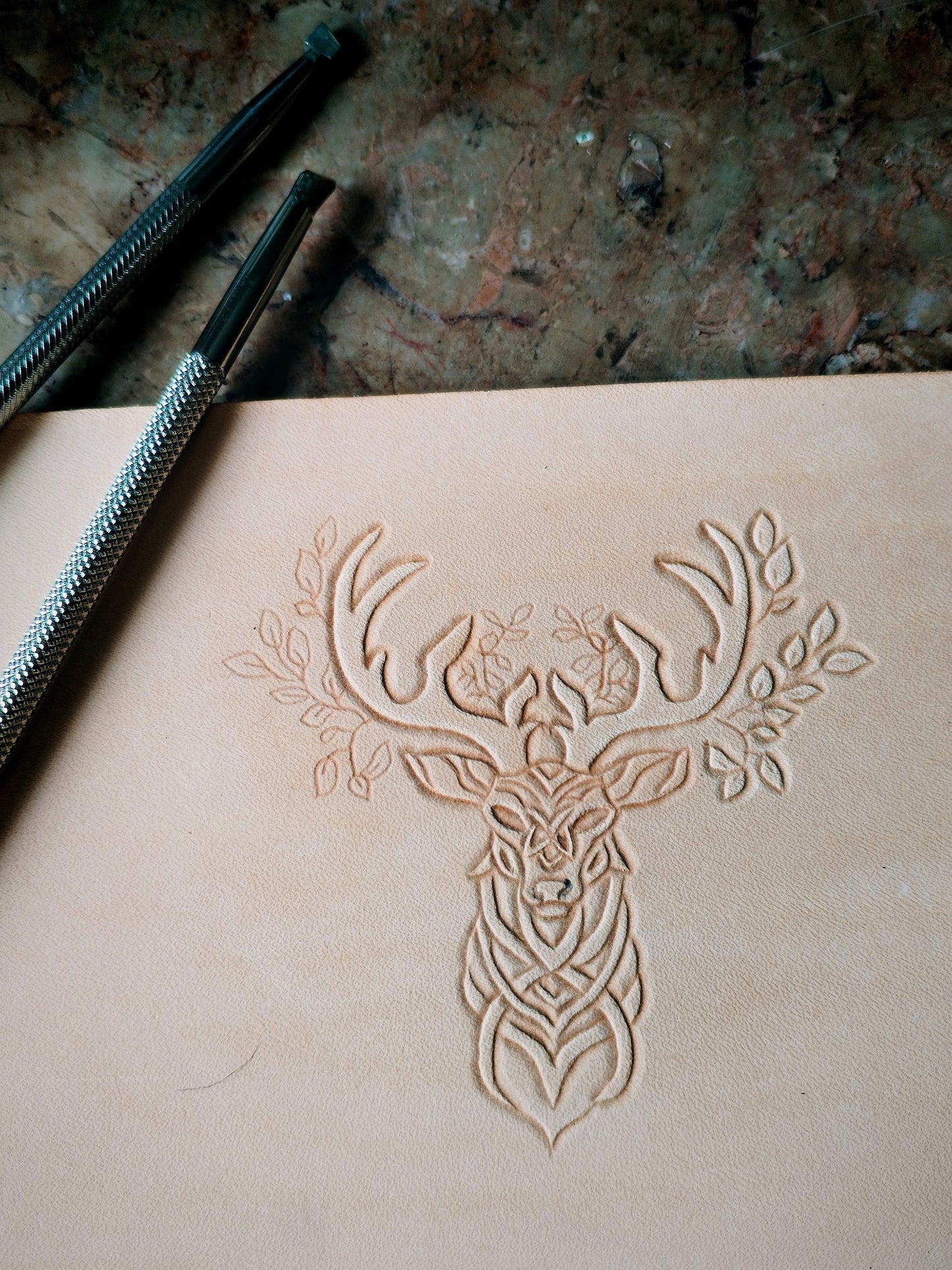 Repoussage à la main du motif cerf sur cuir tannage végétal - savoir-faire artisanal Atelier d'Amrod