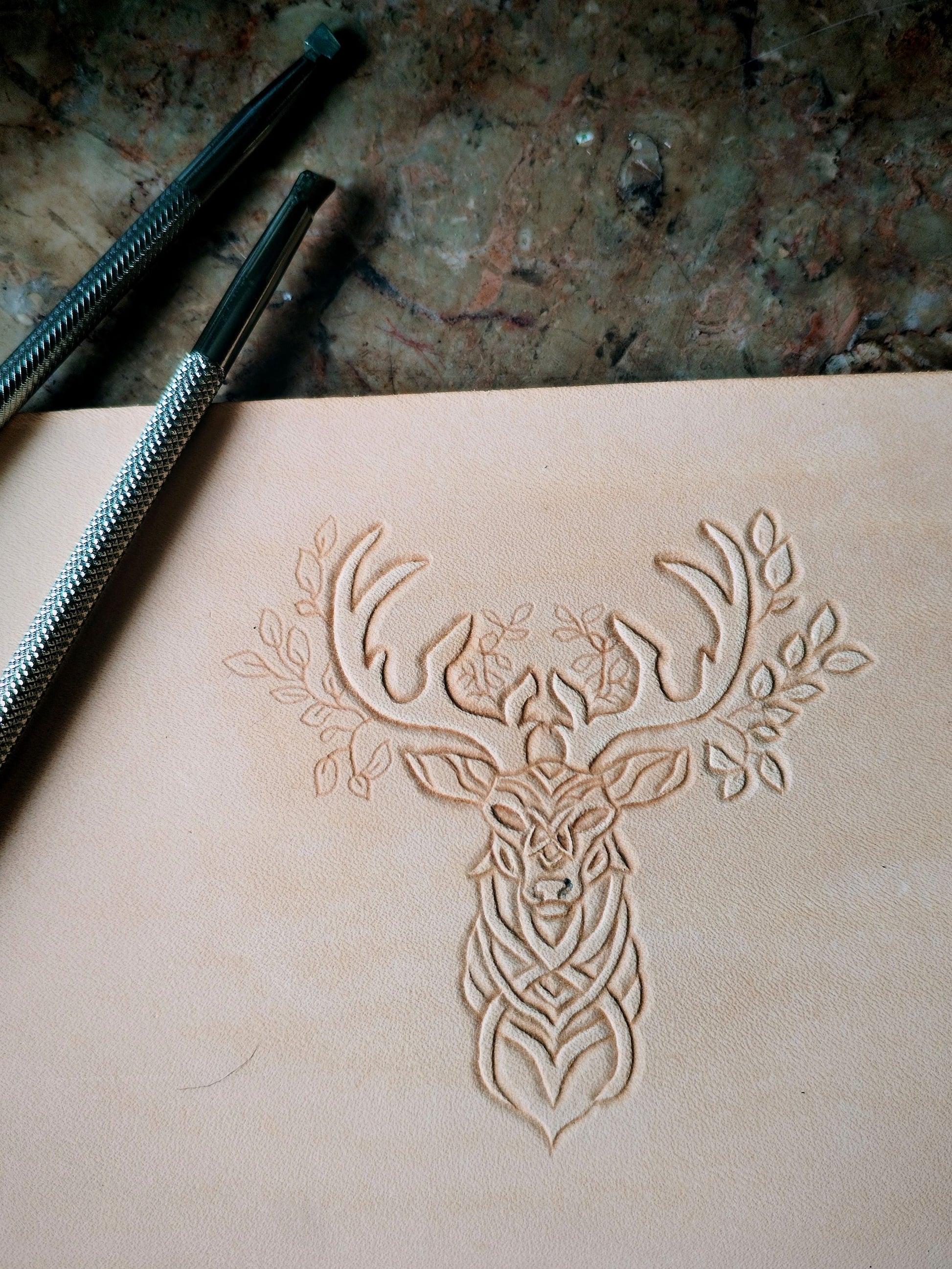 Repoussage à la main du motif cerf sur cuir tannage végétal - savoir-faire artisanal Atelier d'Amrod