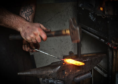 Forgeron Forge Gardarson forgeant à la main une lame de couteau celte au marteau sur enclume - savoir-faire artisanal français