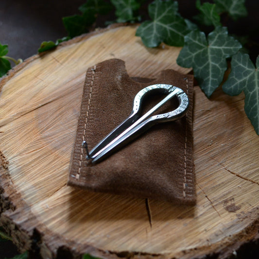 Guimbarde artisanale avec gravures primitives posée sur son pochon en daim