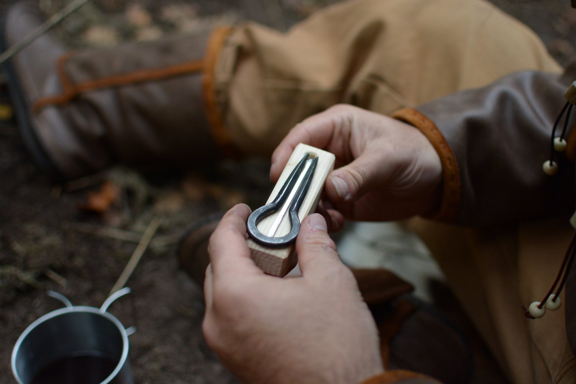 Aventurier tenant la guimbarde sortie de son pochon sur son support en bois