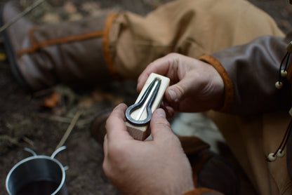 Aventurier tenant la guimbarde sortie de son pochon sur son support en bois