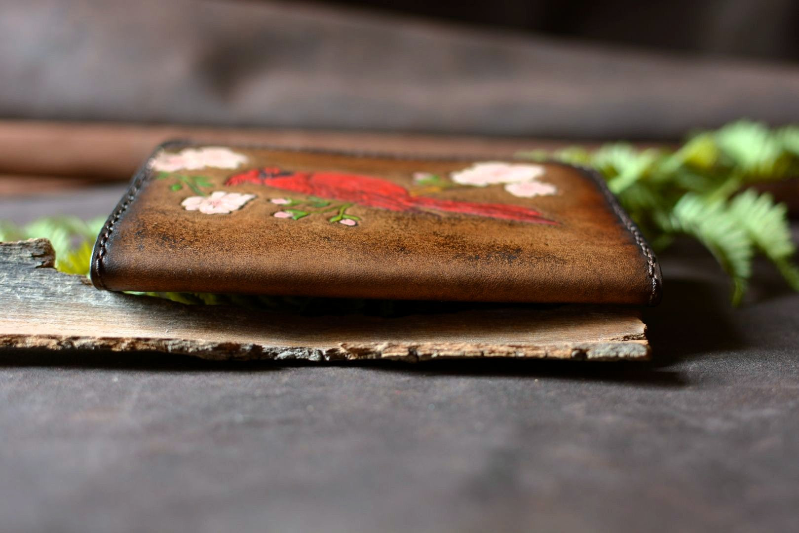 Porte carnet artisanal en cuir naturel motif cardinal rouge - détail face - Atelier d'Amrod